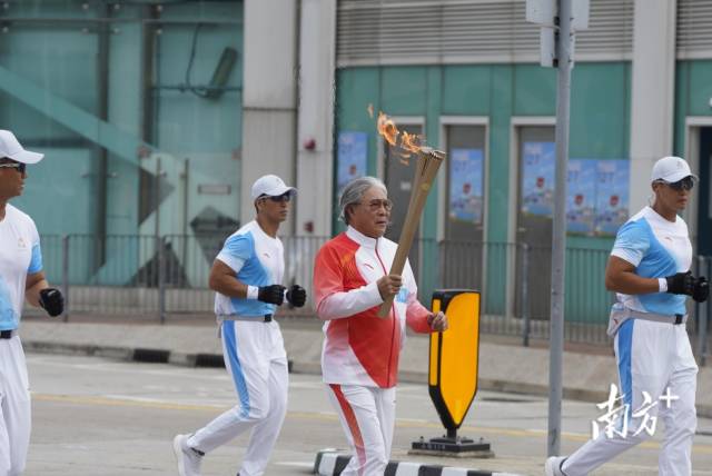 中国香港体育协会暨奥委会会长霍震霆在金紫荆广场传递十五运香港赛区火炬。