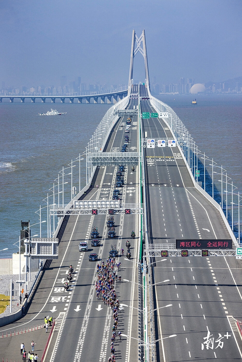 11月8日，第十五届全国运动会公路自行车男子个人赛中，选手们通过港珠澳大桥白海豚人工岛。张由琼 摄