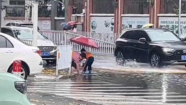 突遇暴雨，东莞一对父子冒雨清理被堵塞的下水道