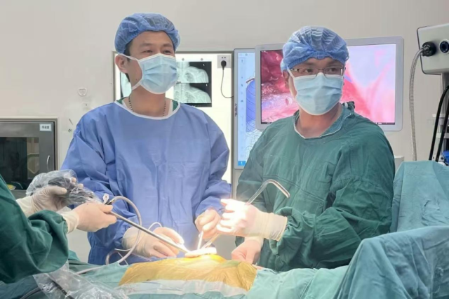 王飞（左1）与邓文炬（右1）在手术中
