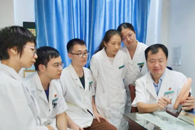 刘继洪（右1）与科室同事探讨耳穴诊疗技术