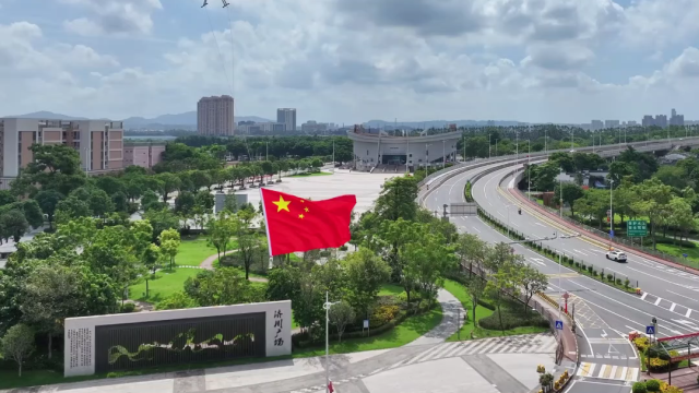 换个角度看中国红！无人机载五星红旗穿梭城市上空