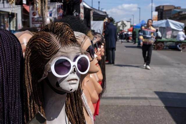 ▲伦敦南部，一个摊位上售卖的假发和墨镜 图/视觉中国