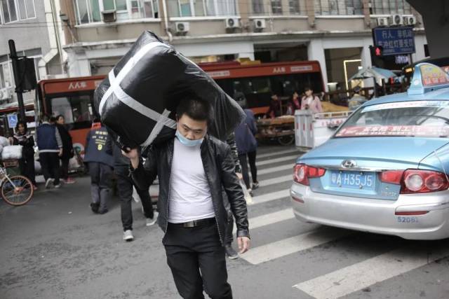 ▲广州十三行服装批发街，进货商大包小包进出批发点 图/视觉中国