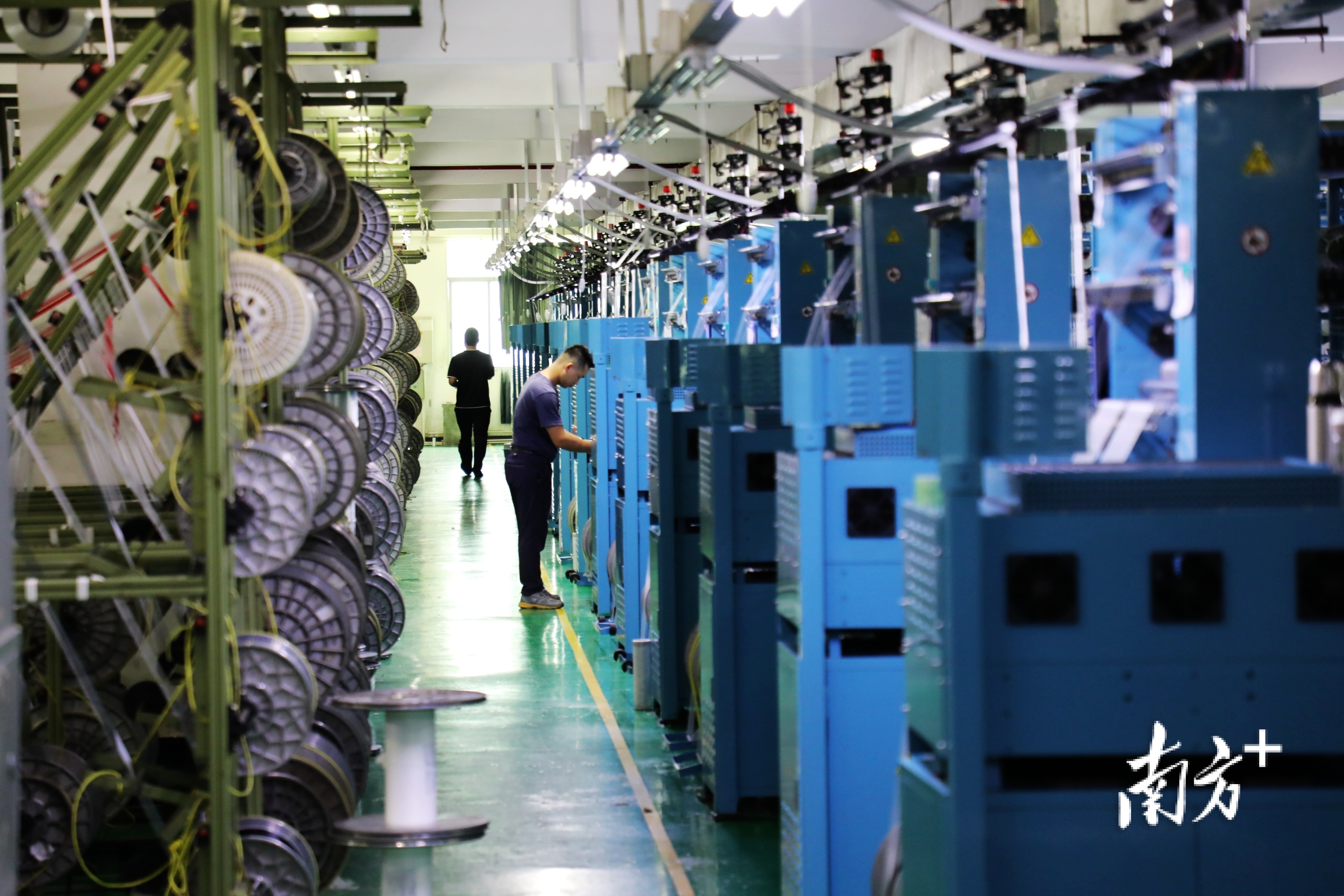 内衣企业生产车间内，全自动生产线高速运转，机械声轰鸣，一派忙碌景象。  南方+ 张伟炜 拍摄