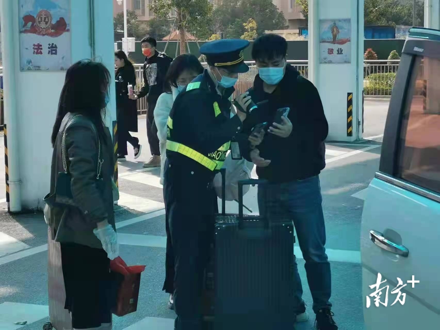 交通执法人员通过手机核对乘客乘坐网约车信息。 吴利婷 摄 交通执法人员通过手机核对乘客乘坐网约车信息。 吴利婷 摄