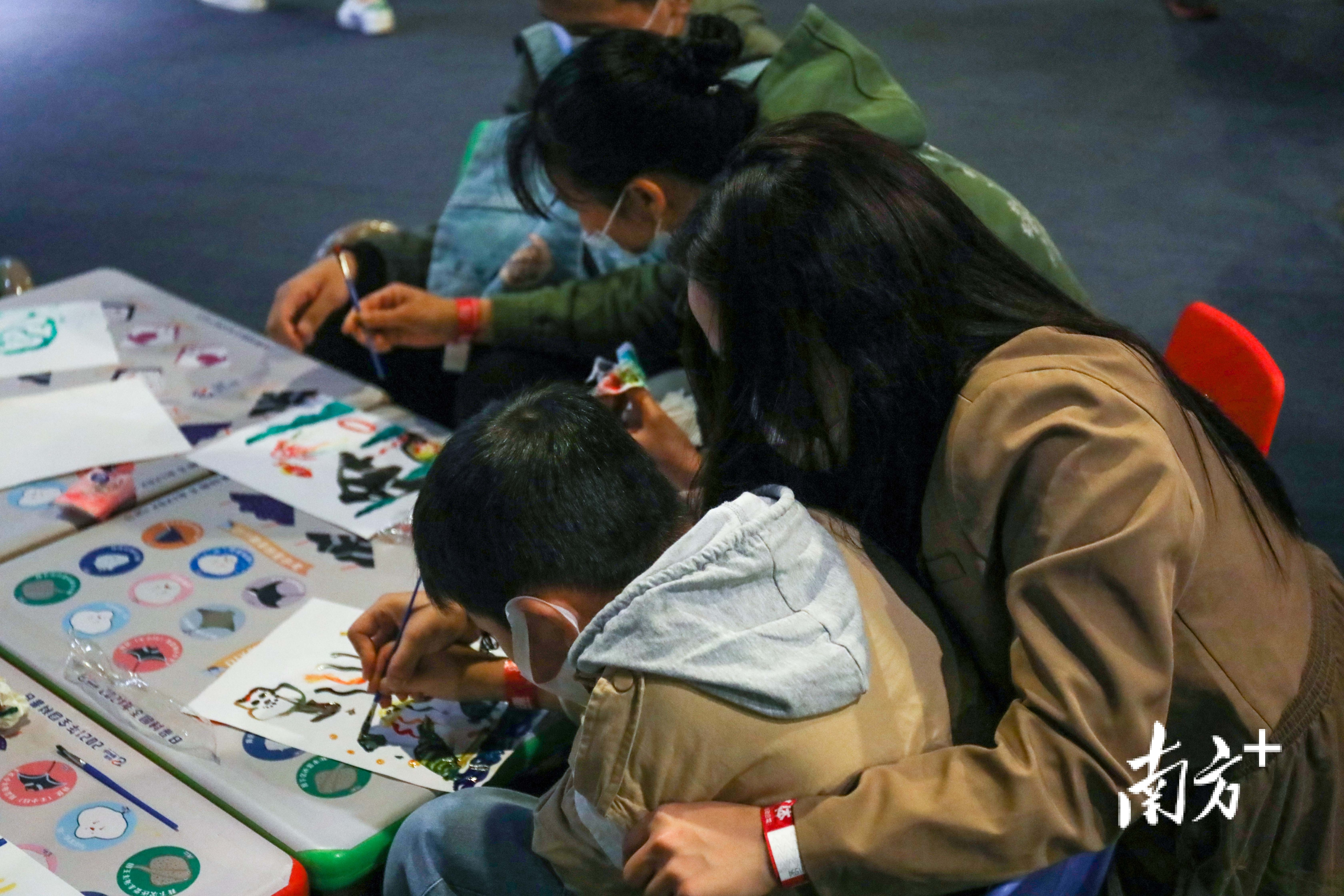 孤独症孩子在父母的帮助下学习画画。 孤独症孩子在父母的帮助下学习画画。
