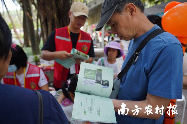 游客们通过宣传手册了解农业外来入侵物种。