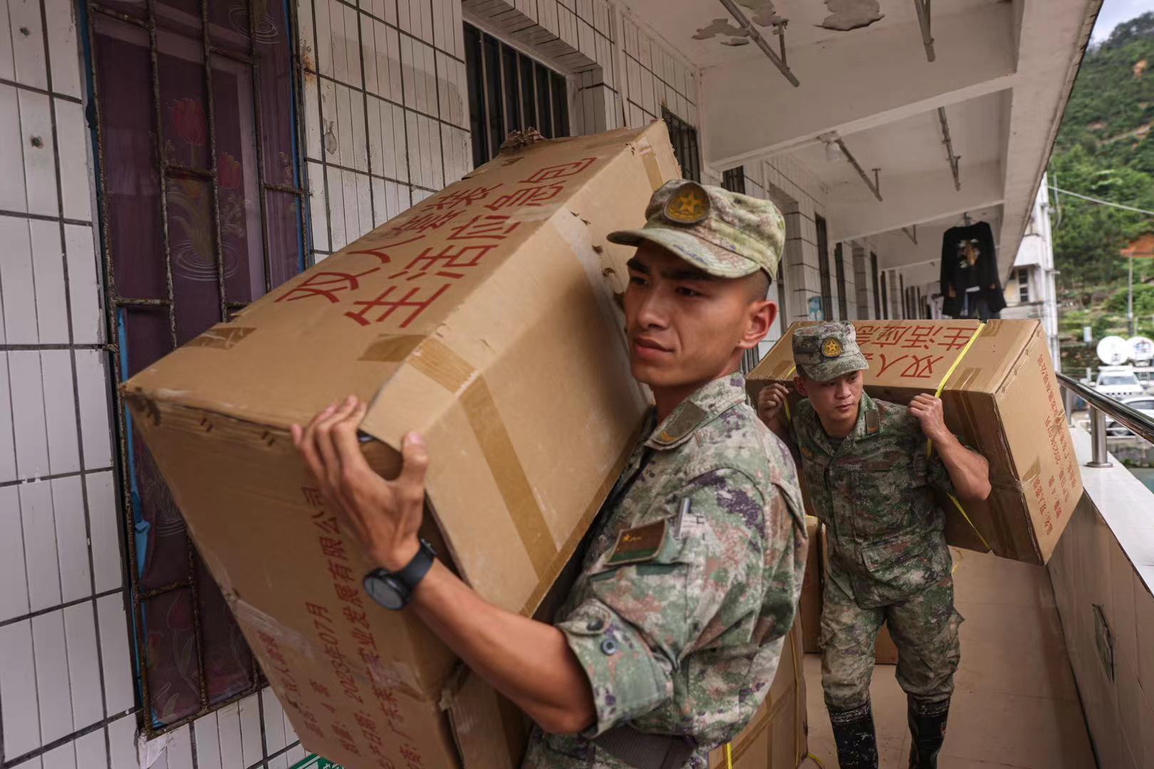 江湾镇江湾中学临时安置点，解放军搬运救灾物资。