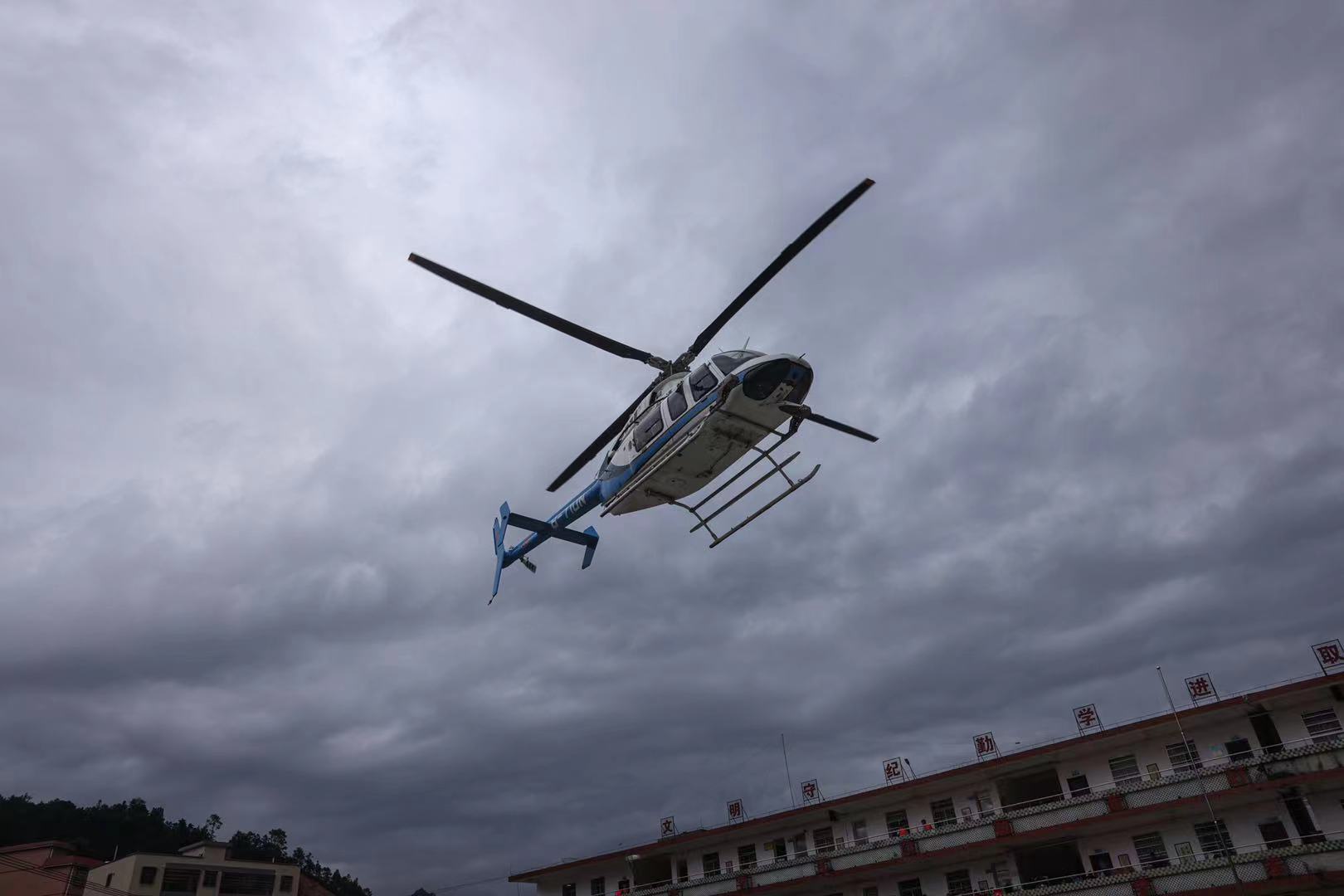 江湾镇江湾中学临时安置点，直升机载着物资抵达，当地居民乘坐直升机离开受灾地。