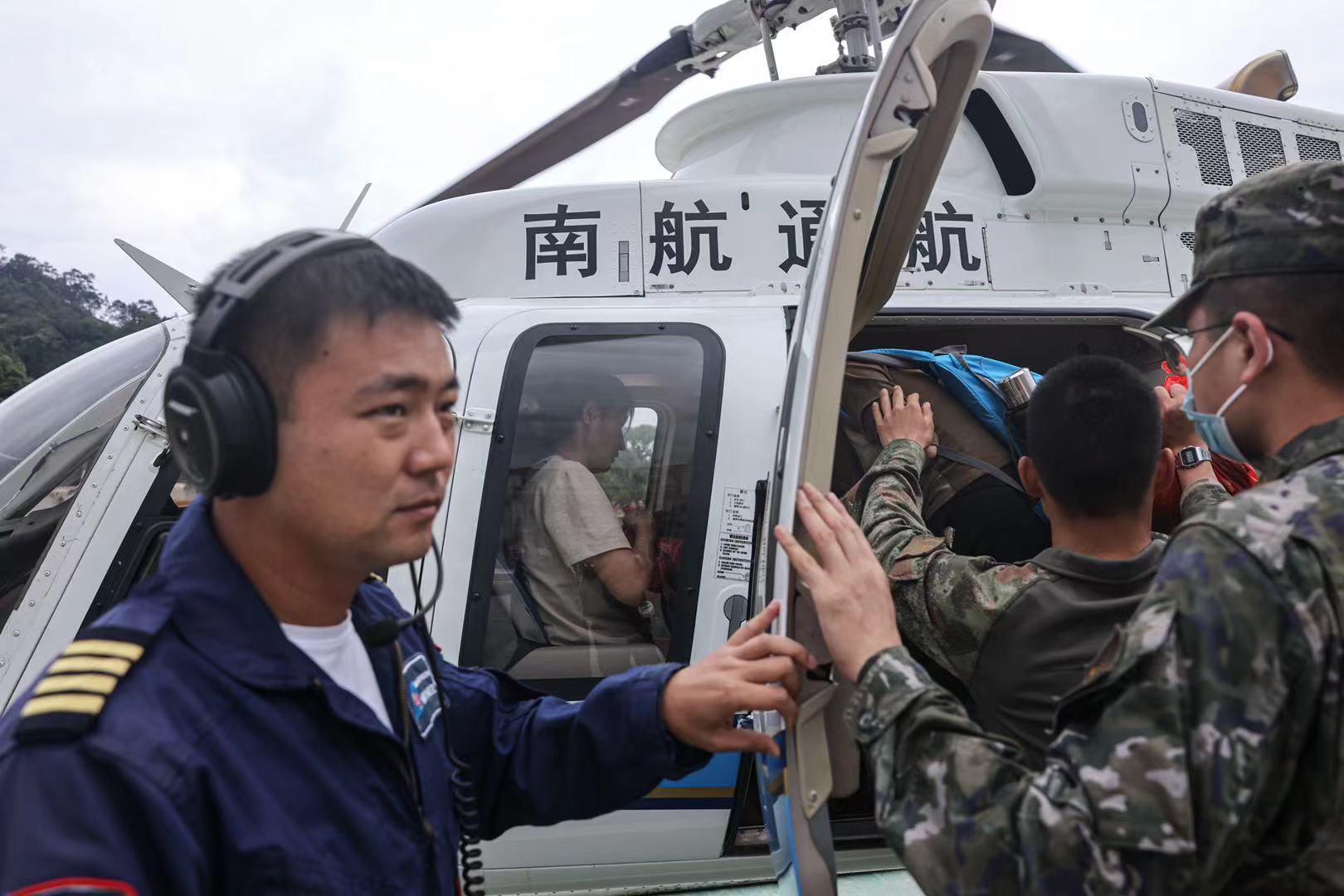 江湾镇江湾中学临时安置点，直升机载着物资抵达，当地居民乘坐直升机离开受灾地。