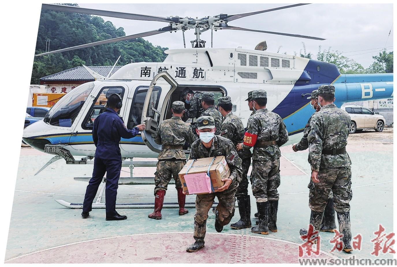 4月23日，直升机载着物资抵达江湾镇江湾中学临时安置点，解放军上前搬运物资。