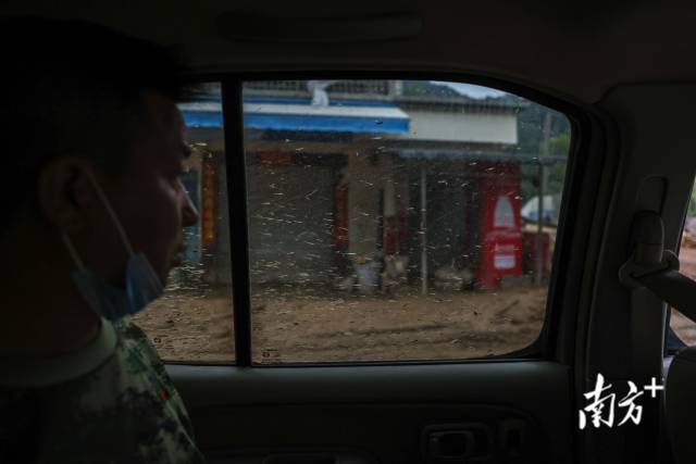江湾镇政府工作人员乘车穿过满是淤泥的街道，挨个前往居民家中，劝说居民转移。  