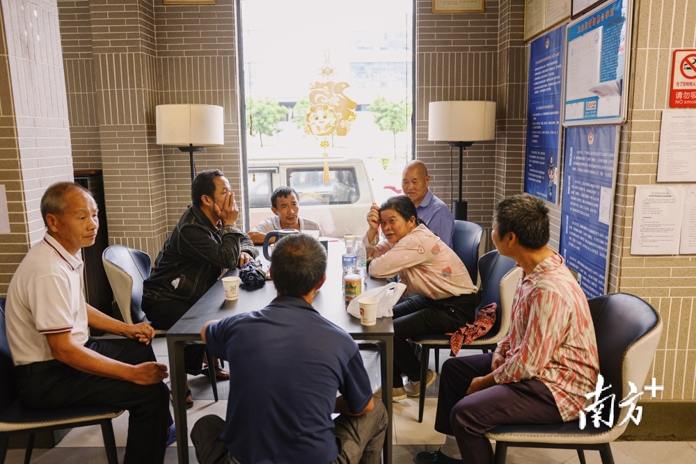 4月25日，韶关武江区，江湾镇湖洋村村民一起坐在安置酒店大堂的茶台前拉着家常，就像他们平时在村口大榕树下一样。