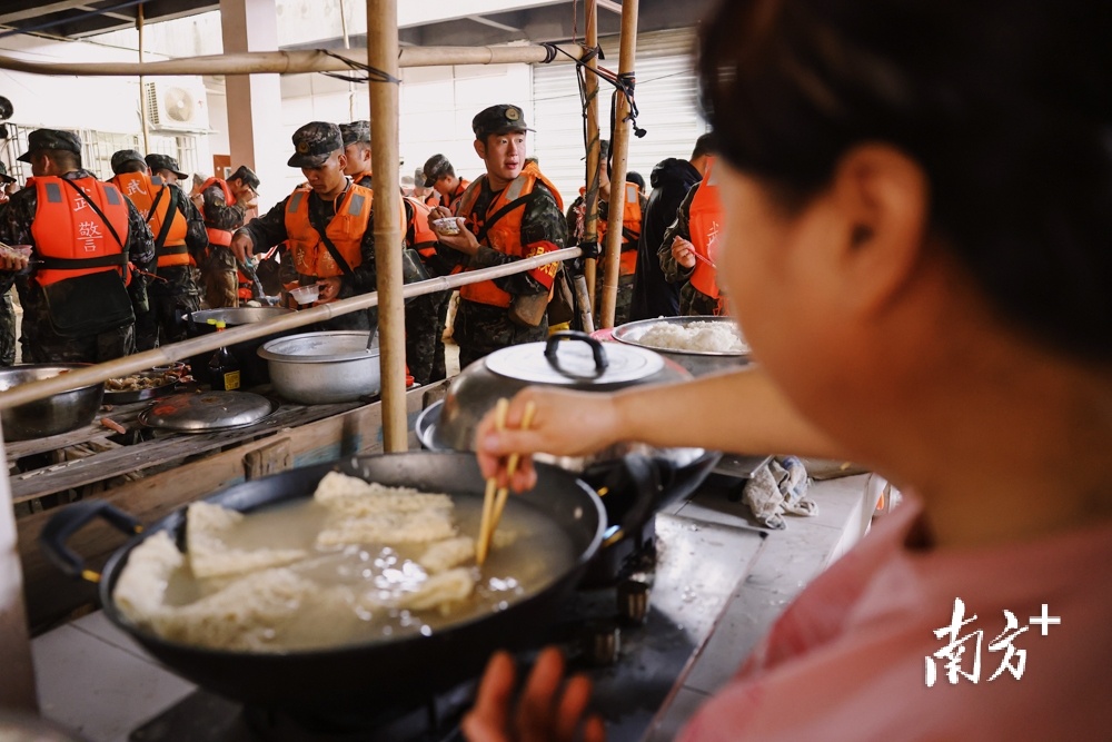 4月22日，韶关江湾镇江湾社区，救援人员吃上当地居民做的饭。  