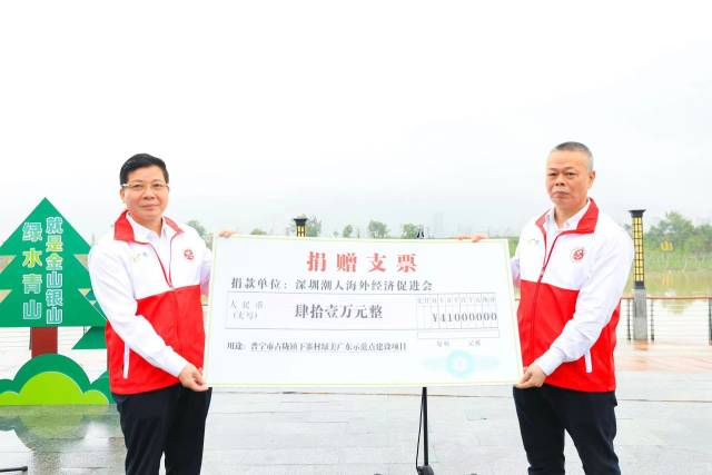 深圳市政協(xié)常委、深圳潮人海外經(jīng)濟(jì)促進(jìn)會會長,、深圳市金晉集團(tuán)董事長周南（左）代表協(xié)會熱心成員向普寧市占隴鎮(zhèn)下寨村捐贈善款助力綠美廣東示范點建設(shè)項目,，普寧市委常委、政法委書記江照明（右）代表接收,。