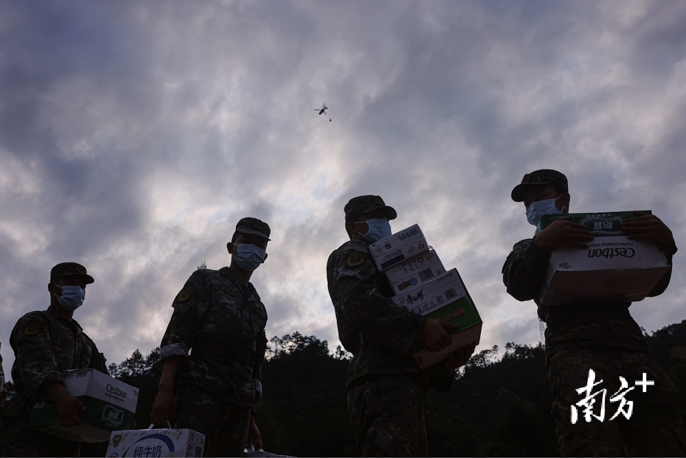 4月23日，韶关江湾镇，解放军搬运救灾物资，空中是空投物资的直升机。  