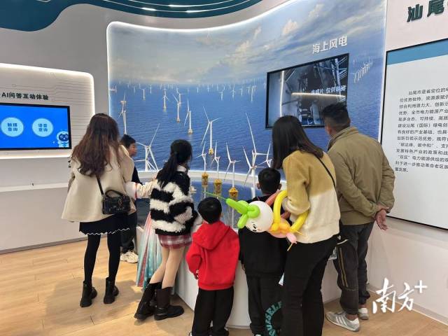 参观者在绿电创新示范基地体验厅观看海上风电模型。