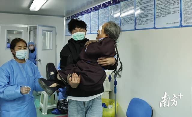 次宗卓玛（右）被家属抱进诊室