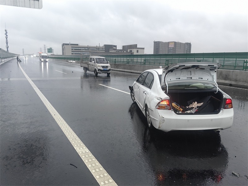 彭警官奔往后方摆放三角反光警示牌。