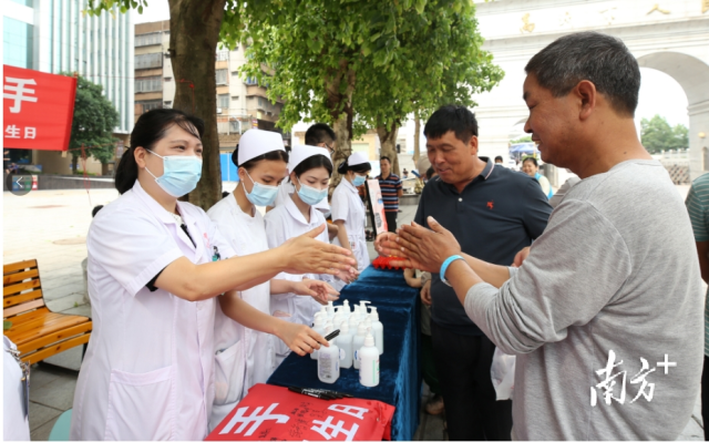 高州市人民医院医护手把手教群众清洁双手。