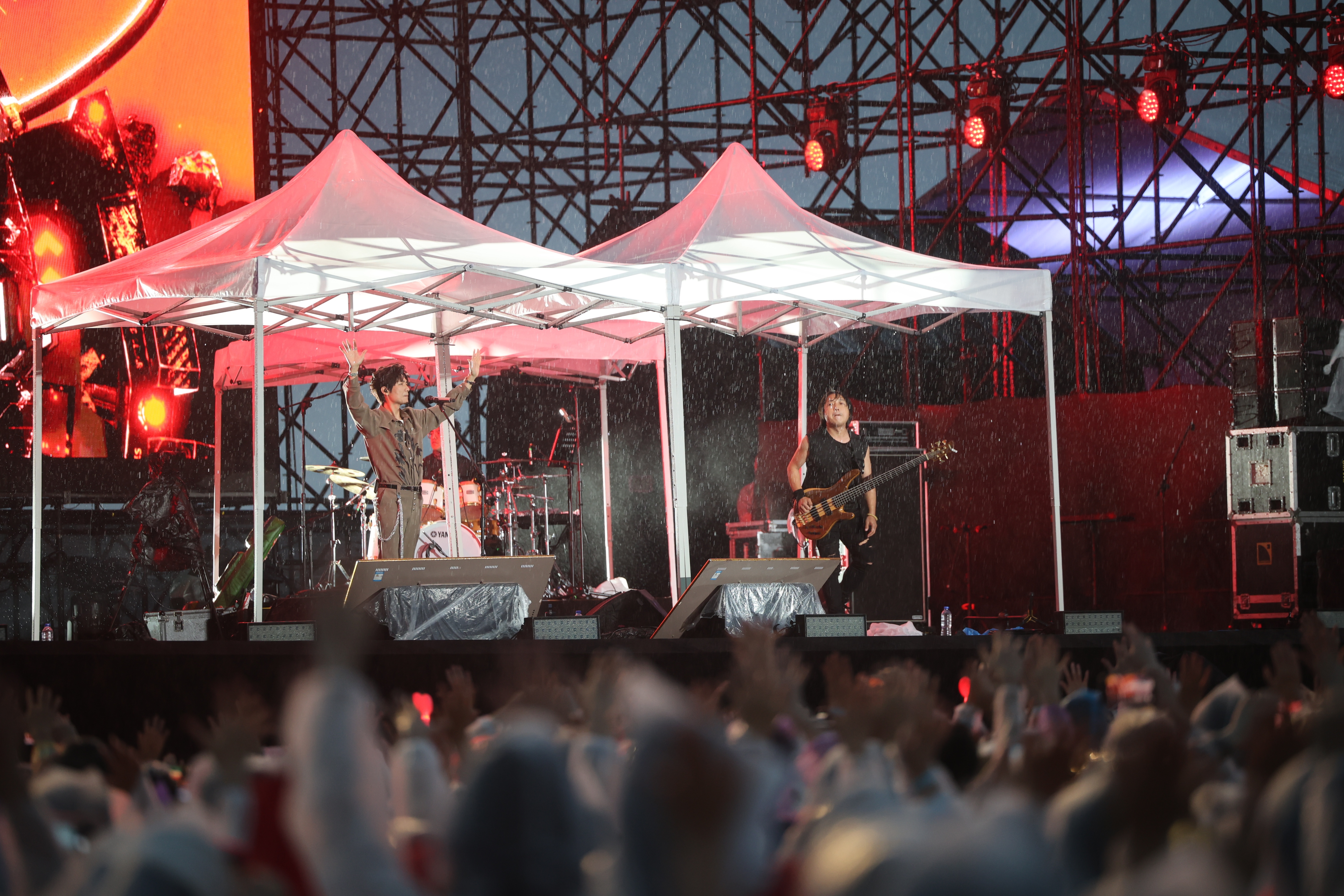 陈楚生与乐队在雨中坚持演出。