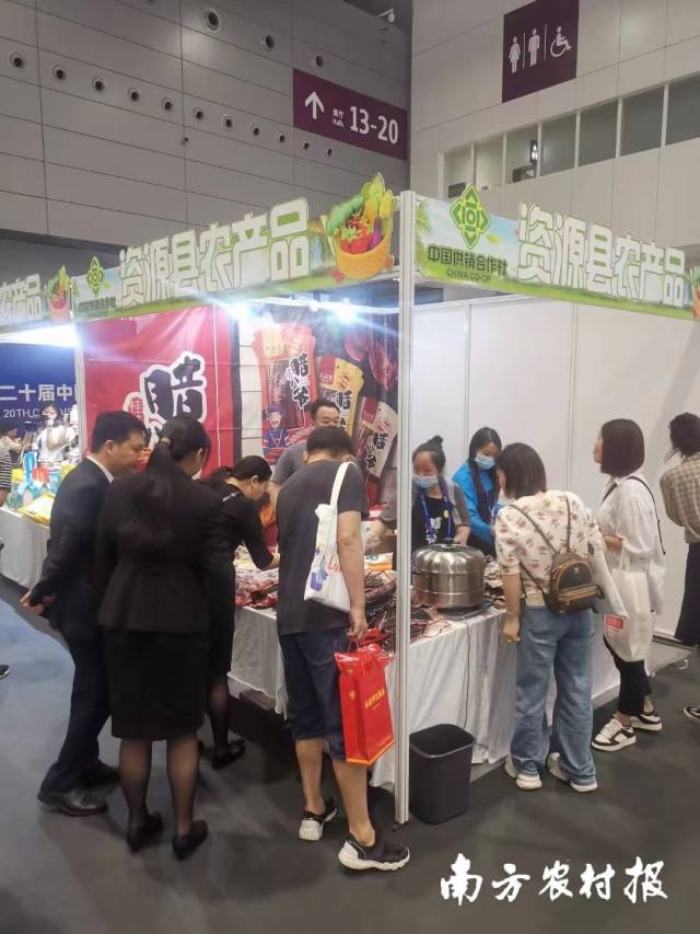 桂林资源县鸿华食物有限公司展位揭示的土猪腊肉排汇良多游客品味置办。