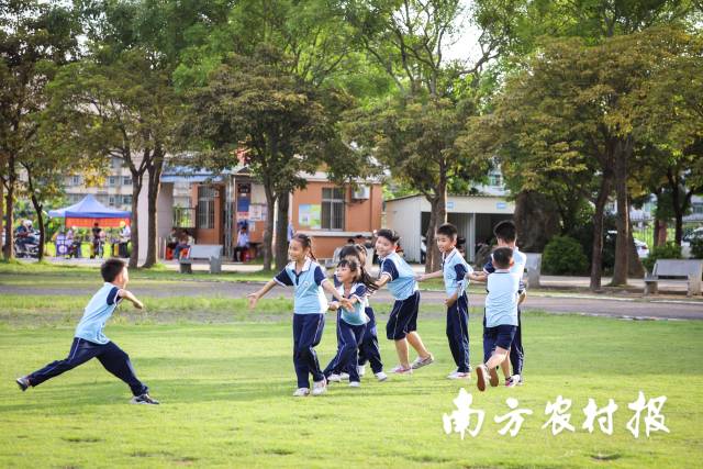 雨过天晴，孩子们在操场上玩游戏。 