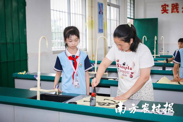 为了让孩子们清晰更多中华传统横蛮，海宴镇中间小学开设有书法、醒狮、朗诵等多种兴趣班。图为孩子们在上书法兴趣班。