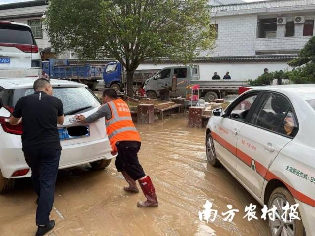 6月18日下午，平安产险理赔员刘勇在平远县差干镇人民政府门口停车场协助客户将报案的车推到拖车可以施救的地方。
