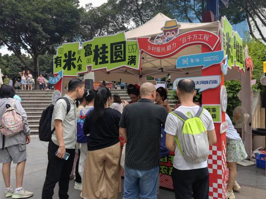 众多游客现场试吃和购买高州农产品。