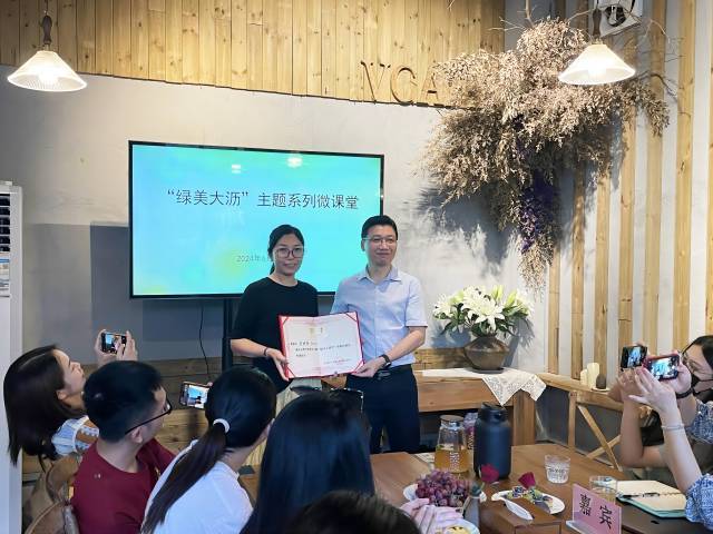 大沥镇党委委员冼兆鹏（右）向V Cafe创始人颁发聘书