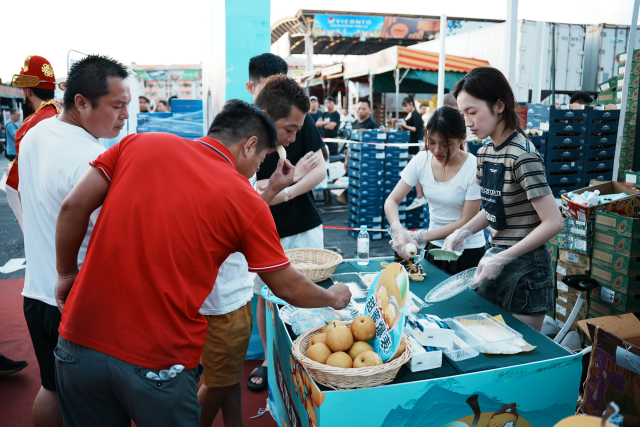 市场内商家试吃连州水晶梨，品味寿乡“幸福甜”。