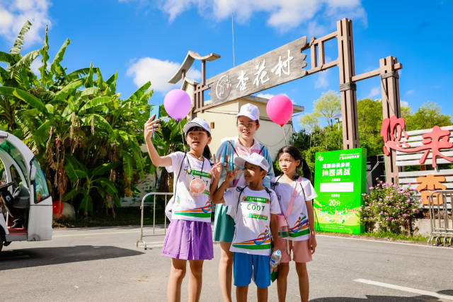 城市家庭在杏花村村口拍照打卡,。