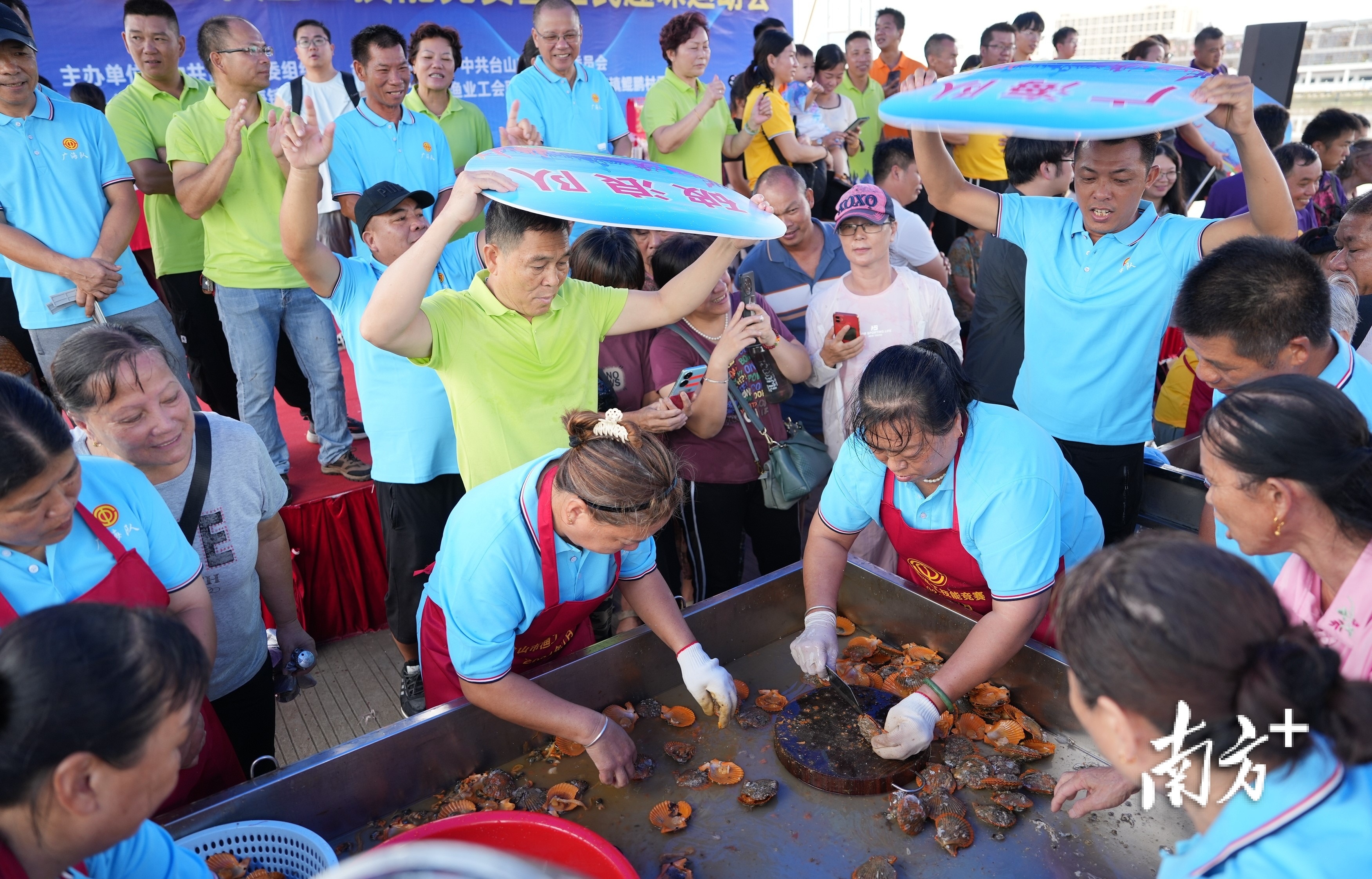 开扇贝比赛,队友为参赛者扇风。 开扇贝比赛,队友为参赛者扇风。