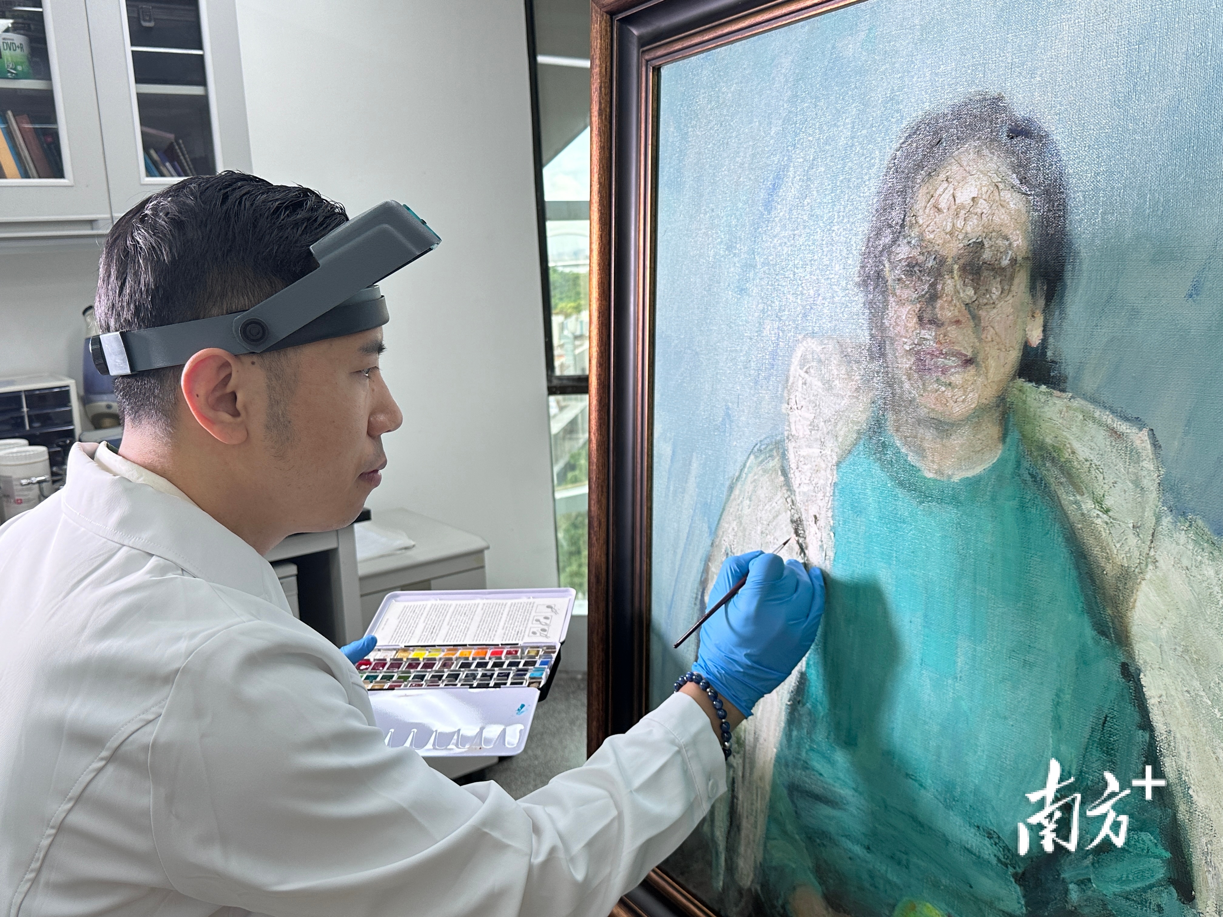 莫述文正在修复汤小铭油画《悠然》。受访者供图。