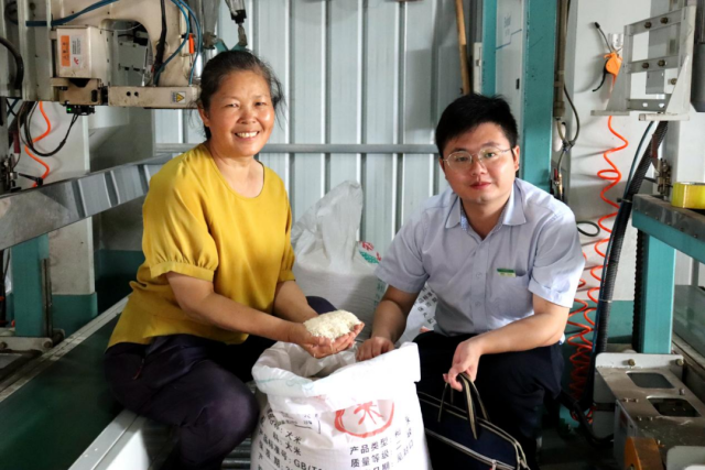 南雄市冠奕通粮食加工有限公司负责人徐石凤自豪地向邮储银行韶关市分行工作人员展示其公司生产的高品质、颗粒饱满的大米。