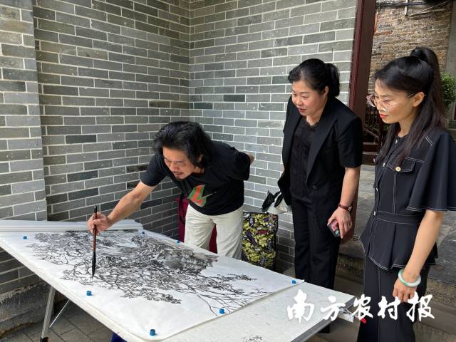 画家田其斌（左一）在黄姚古镇内写生。