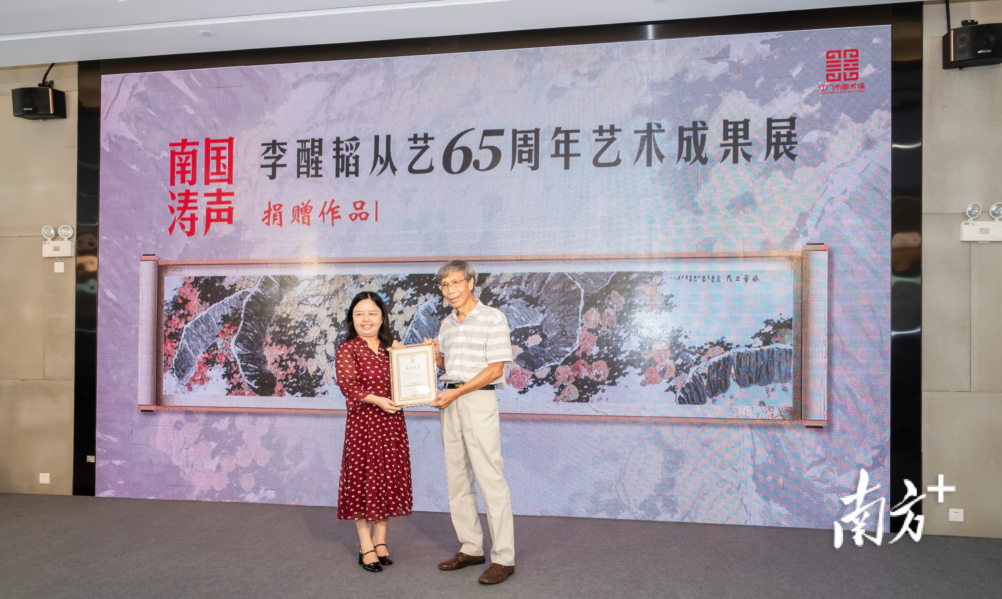 江门市文化广电旅游体育局党组成员、副局长周传艳为李醒韬颁发证书 。