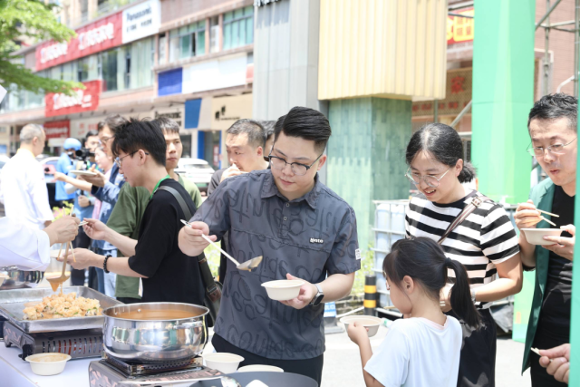 现场鉴赏的市夷易近纷纭试吃以麻竹笋为质料的菜品。