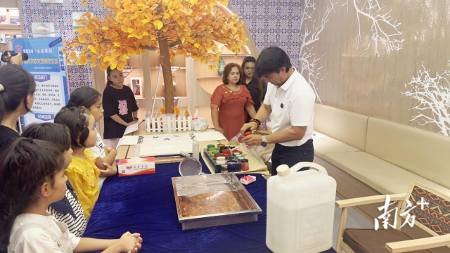 书展上，喀什传统民间手工艺人为各族群众演示特色手工艺品的制作。