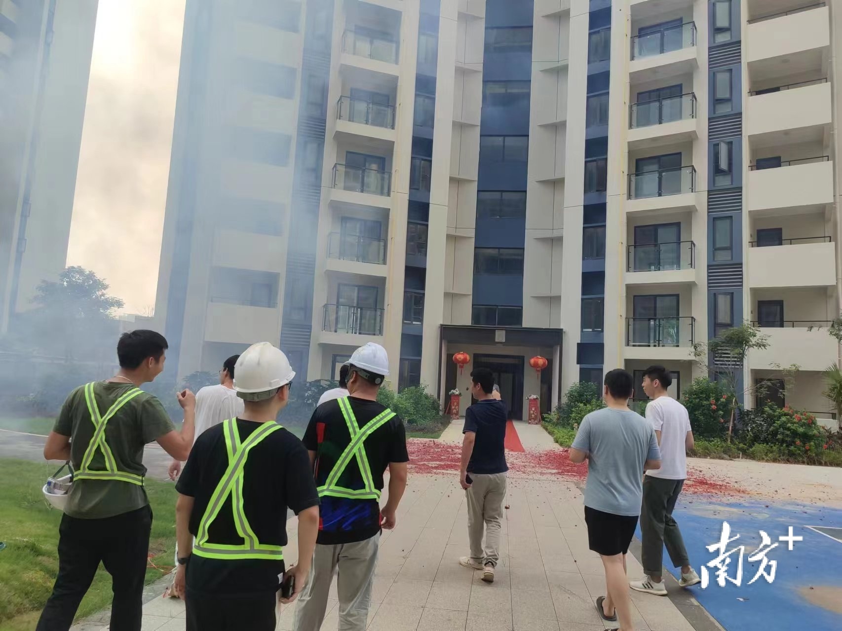 6栋楼前燃放鞭炮，施工人员陪同业主验房。