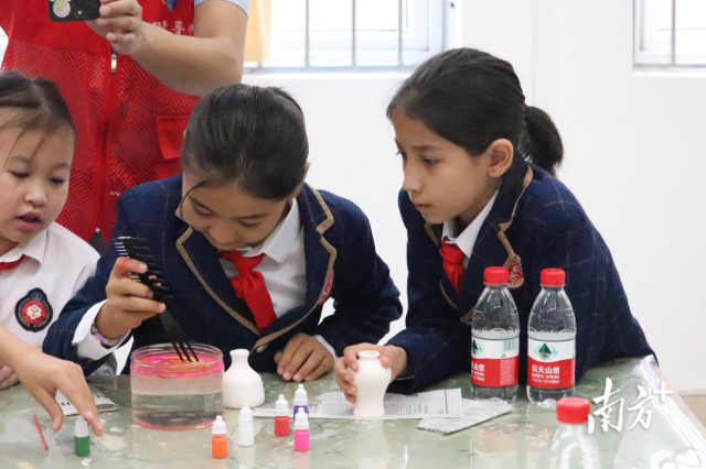 托小学生体验非遗水拓。