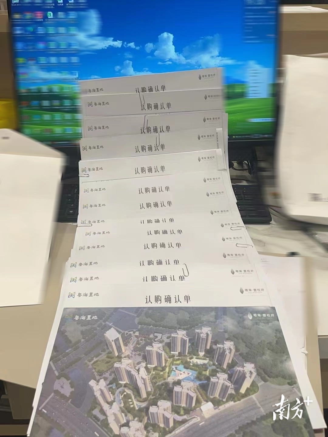 桌面堆满了国庆首日成交客户的认购单。