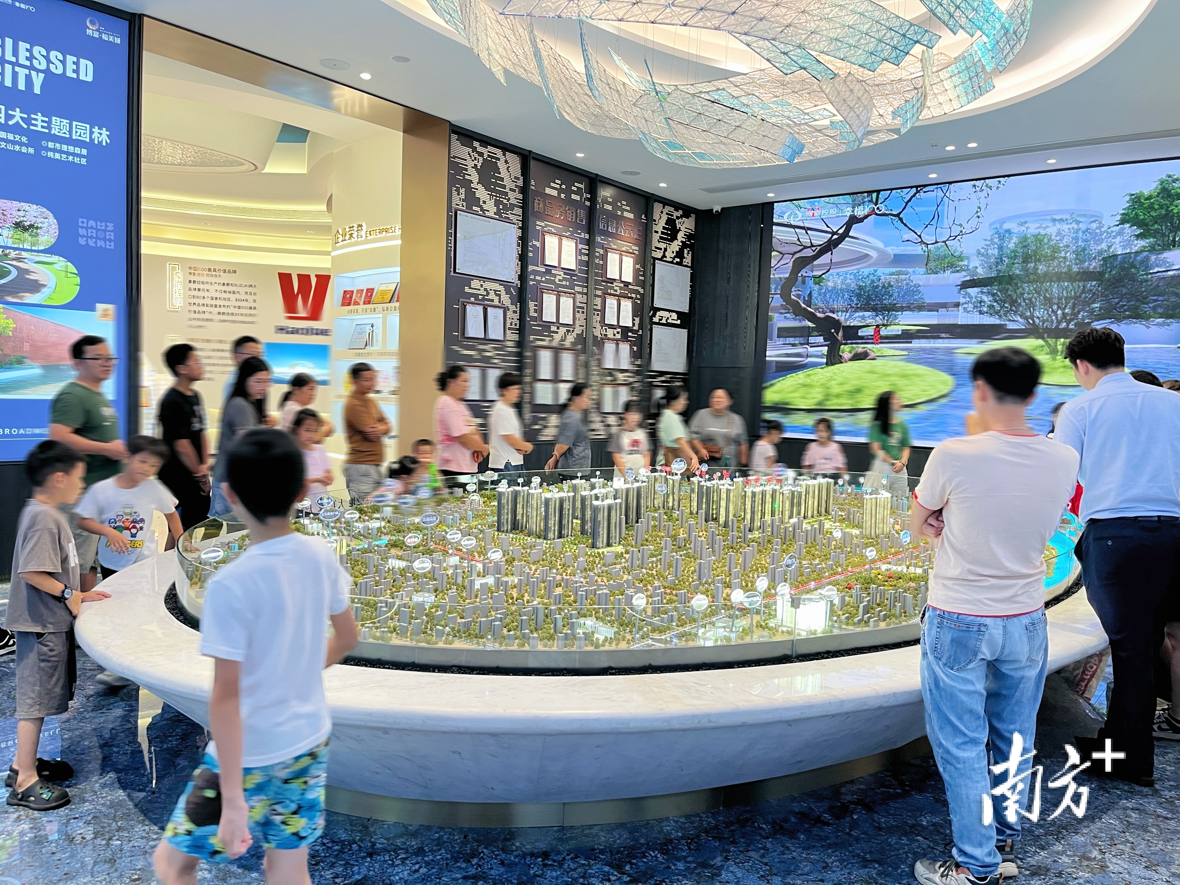 销售人员正在沙盘处给购房者介绍项目情况。受访者供图