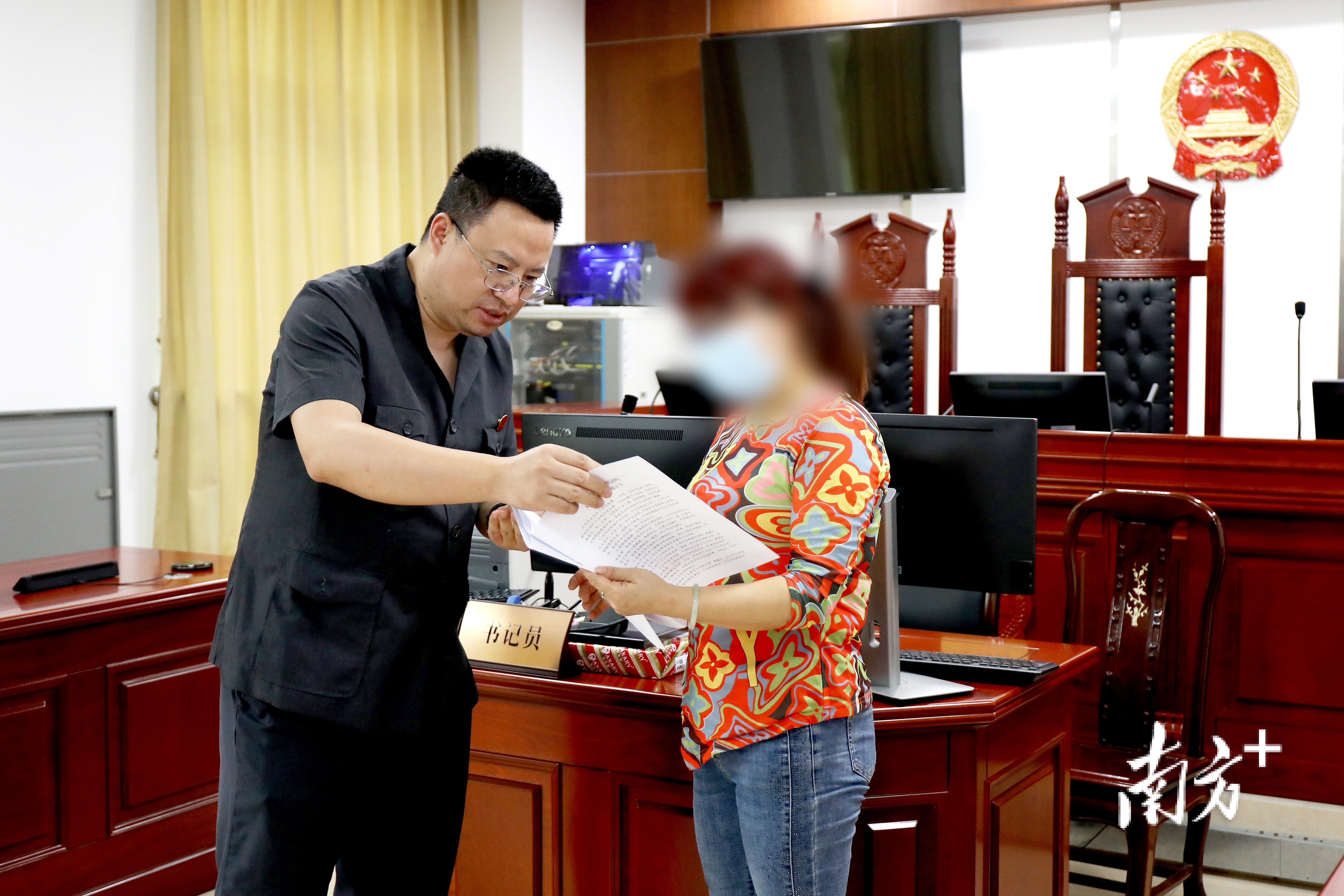 鹤山法院审判团队向当事人发放《关爱未成年人提示卡》。