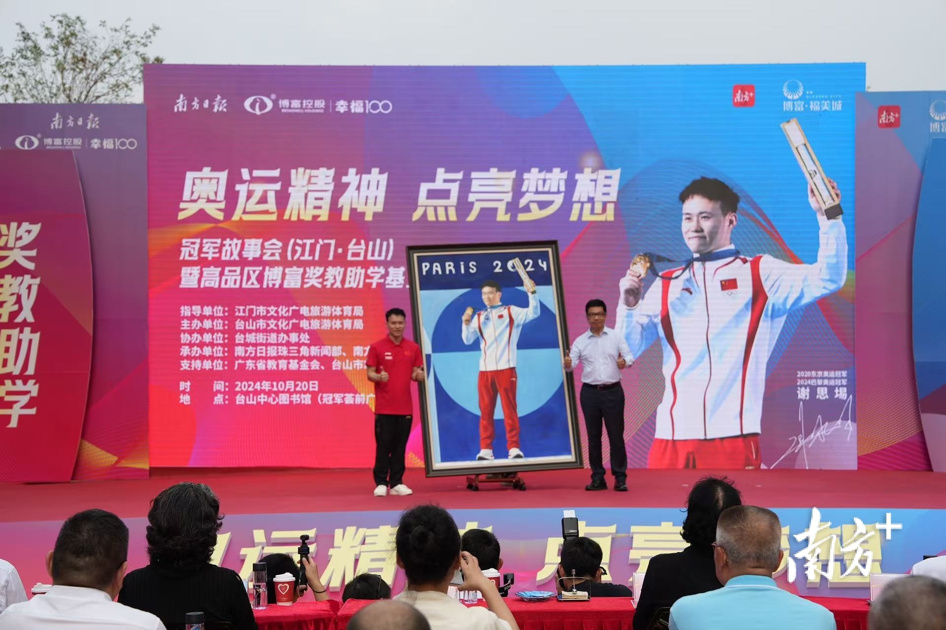 谢思埸在肖像油画上签名。这幅肖像油画将珍藏于台山中心图书馆（冠军荟）。