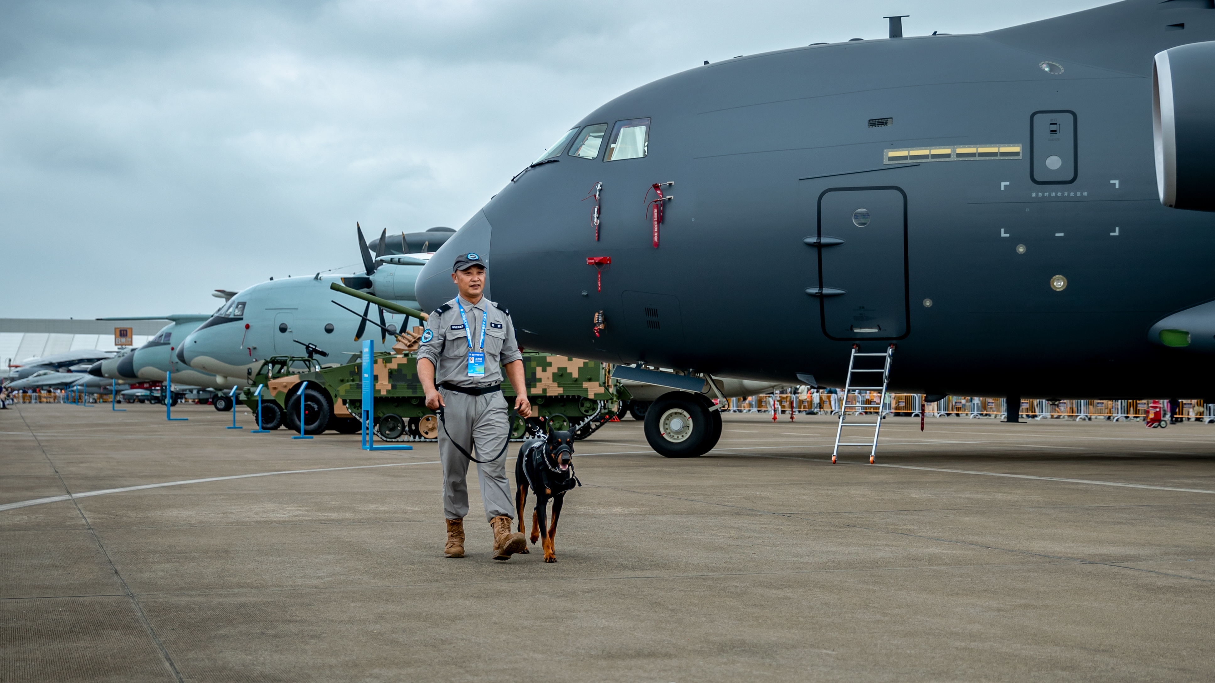 安保人员带着警犬在航展区巡逻。
