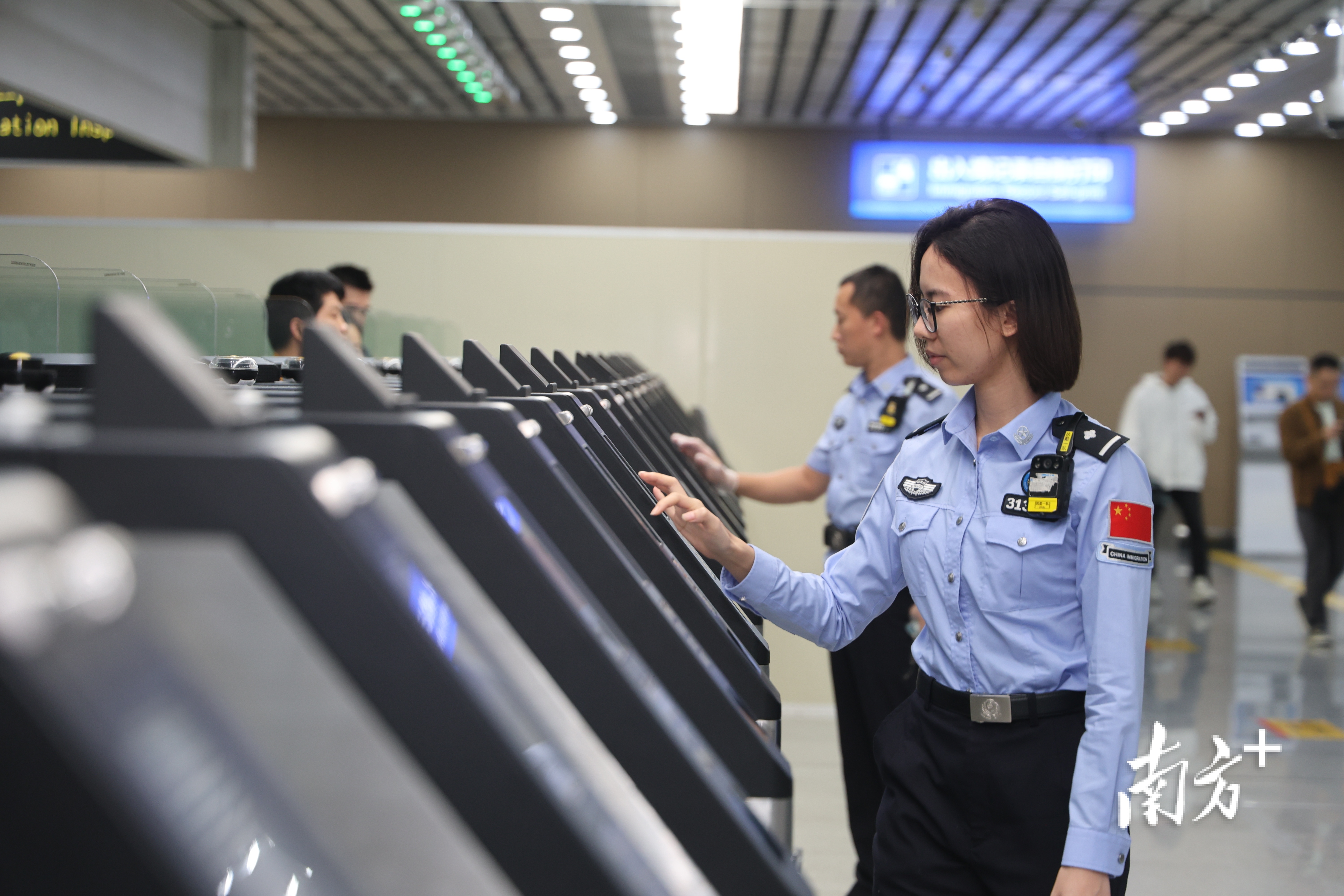 边检人员协助旅客使用系统快速通关。 边检人员协助旅客使用系统快速通关。