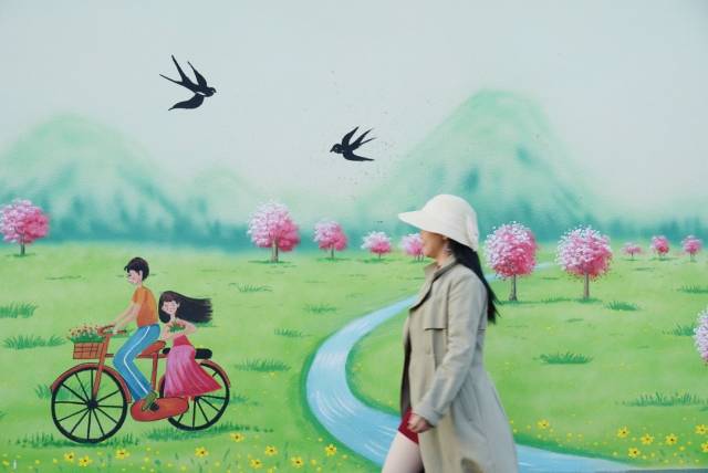 采风团成员“置身”墙绘里的美丽乡村。